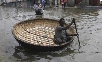 Un hombre utiliza una 'coracle', una pequeña barca circular hecha de bambú durante las inundaciones en Chennai (India).