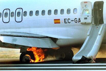 El aparato, en el aeropueto de El Prat con uno de los heridos en el suelo mientras arde el tren de aterrizaje.