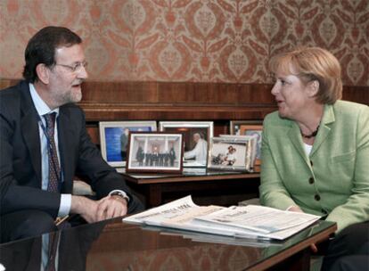 Mariano Rajoy conversa con la canciller alemana, Angela Merkel, durante la reunión del Partido Popular Europeo en Varsovia.