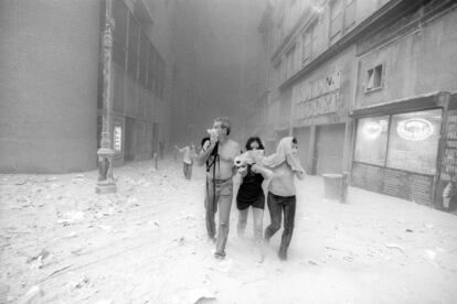 La mayor operación de rescate de la historia estaba en marcha. Sobre las 10.45, trabajadores de la zona corren por las calles de Nueva York, cubriéndose las caras a causa del polvo que cubrió la ciudad tras derrumbarse las torres gemelas. En la imagen, en John Street.