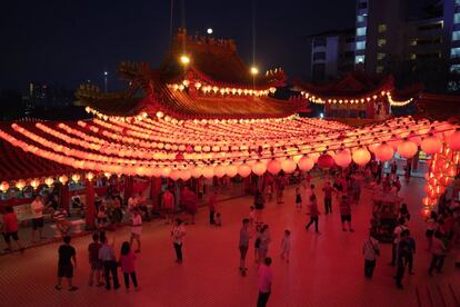 Los visitantes se reúnen bajo la luz roja de las linternas del templo, el 4 de febrero de 2019, en Kuala Lumpur, Malasia.