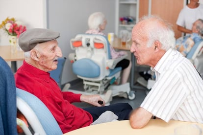 Un centenario habla con su hijo en una residencia para ancianos. 
