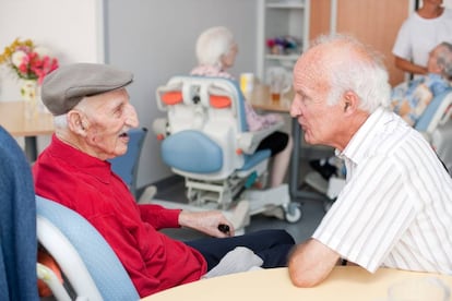 Un centenario habla con su hijo en una residencia para ancianos.