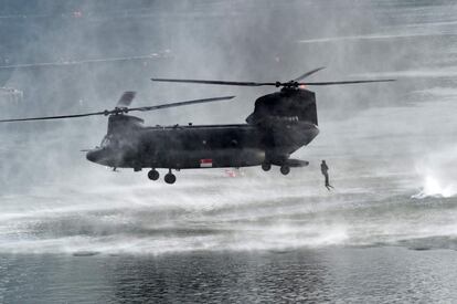 Un buzo de la armada de Singapur salta desde un helicóptero Chinook durante el desfile que conmemora el 52º aniversario del Día Nacional, en Singapur.