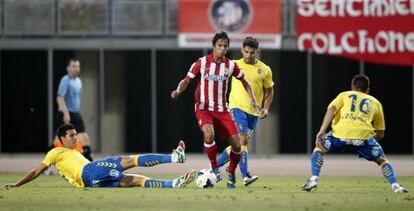 Olíver Torres, del Atlético, rodeado de rivales del UD Las Palmas en un amistoso.