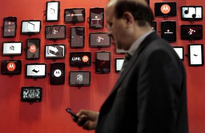 Un hombre consulta su m&oacute;vil ante el stand de Motorola del Mobile World Congress, en febrero de 2012, en Barcelona. 