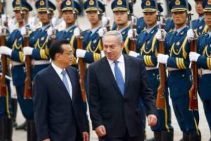 El primer ministro israelí, Benjamin Netanyahu (dcha), y su homólogo chino, Li Keqiang (izda), revisan la guardia de honor durante una ceremonia de bienvenida en Pekín (China) hoy, miércoles 8 de mayo de 2013.