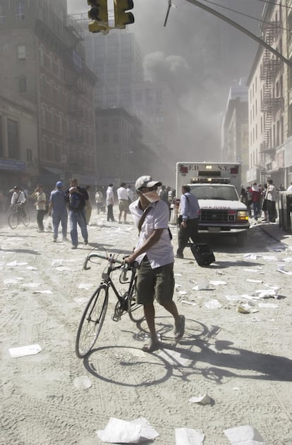 Escombros y humo nublaron y llenaron las calles del Bajo Manhattan. En la imagen un ciclista tapado con mascarilla se aleja de la 'zona cero'.