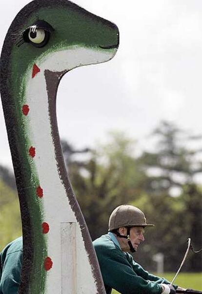El duque de Edimburgo, que participó este fin de semana en Escocia en una carrera de carros de caballos, pasa trás un muñeco del legendario <i>Nessie.</i>