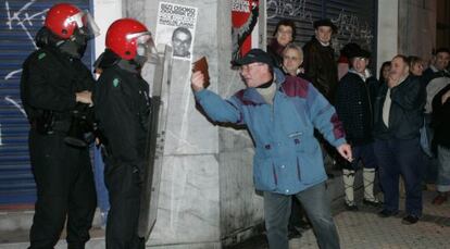 Una pareja de agentes soporta con paciencia los reproches de un ciudadano durante un acto en San Sebastián.