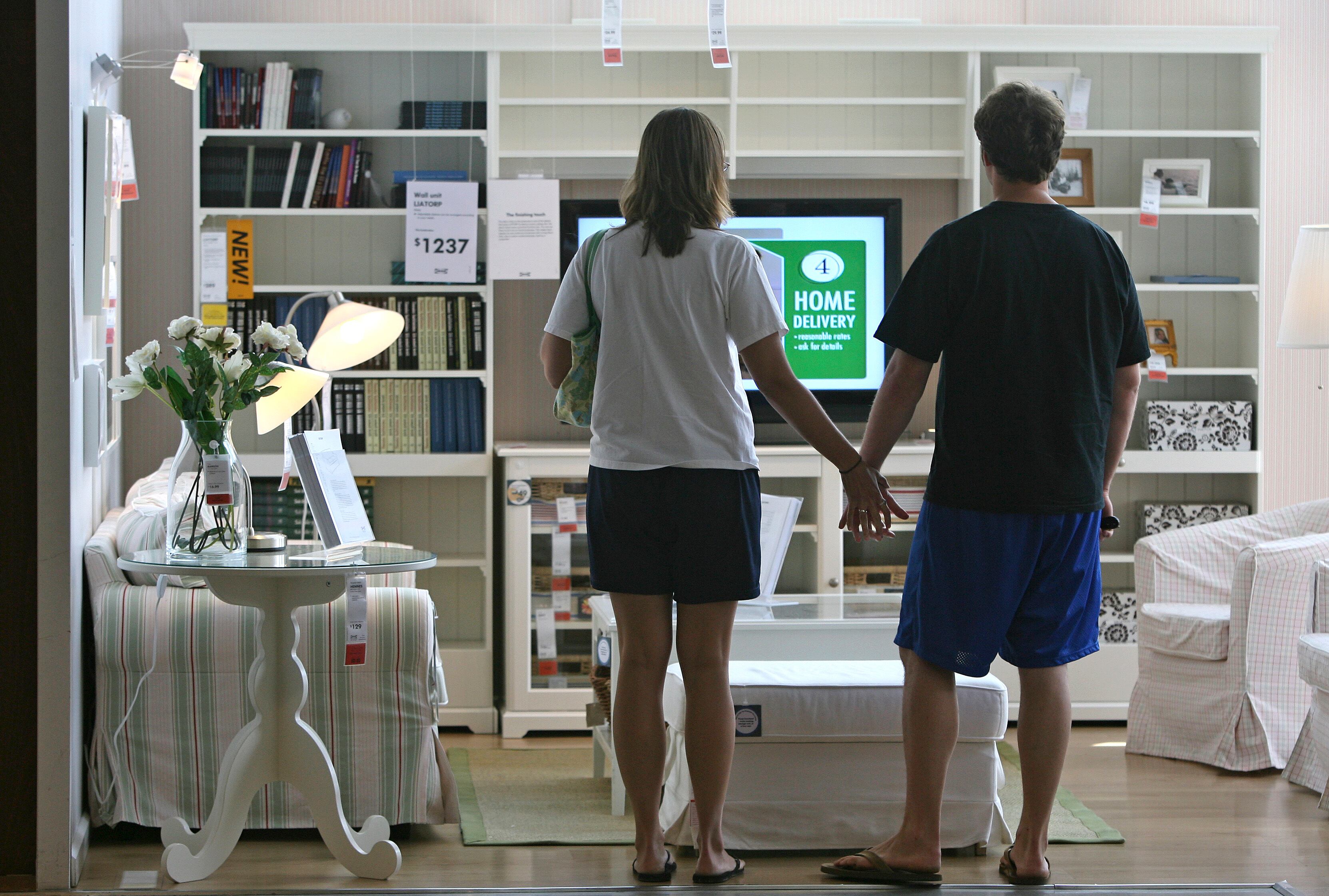 Una pareja se da la mano ante un salón vacío de un Ikea de Chicago.