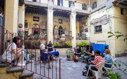 Personas reunidas en el patio de la librería Niña Oscura para la lectura.