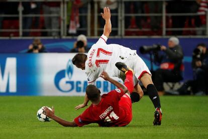 Fernando, del Spartak, y Sergio Escudero, del Sevilla, caen al suelo después de una jugada.
