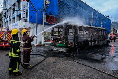 Bomberos controlan el incendio de un autobús.