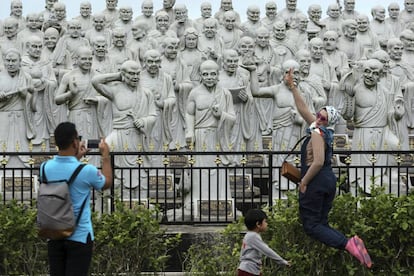 Una turista posa en frente de estatuas Bodhisattva en el templo Ksitigarbha en Tanjung Pinang (Indonesia). Dicho templo budista está siendo uno de los destinos religiosos más visitados de la provincia de las Islas Riau. El nombre de las esculturas, construidas en 2010, es '1.000 caras'.