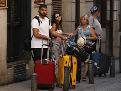 Varios turistas con maletas en el centro de Madrid.