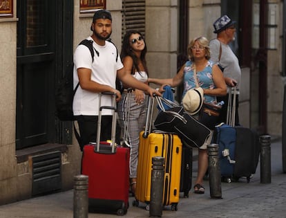 Varios turistas con maletas en el centro de Madrid.