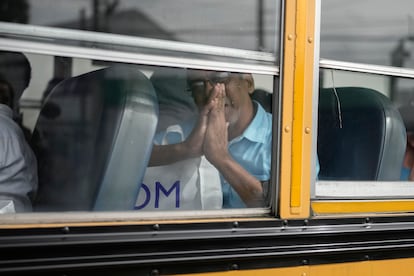 A formerly incarcerated individual makes signs of gratitude while being transported by bus through Guatemala City.