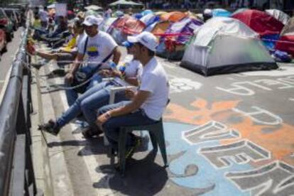 Un grupo de manifestantes opositores al Gobierno de Nicolás Maduro, se encadena durante una manifestación frente a las oficinas del Programa de las Naciones Unidas para el Desarrollo (PNUD) en Caracas (Venezuela).