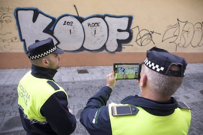 Agentes de la policía local de Málaga realizan fotos a uno de los grafitis aparecidos en una de las calles de la ciudad.