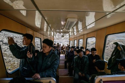 De acuerdo con Ri Yong Myong, estudiante de literatura coreana en la Universidad Kim Il Sung en Pyongyang, los norcoreanos ven en Monte Baekdu algo más que honores y riquezas. "Todos necesitan pilares espirituales", y así es vista la montaña según Ri Yong Myong, de 30 años, quien además estuvo alistado en el ejército durante 10 años. En la imagen, estudiantes utilizan sus móviles para hacer fotografías durante el viaje hacia la cima de Monte Baekdu.