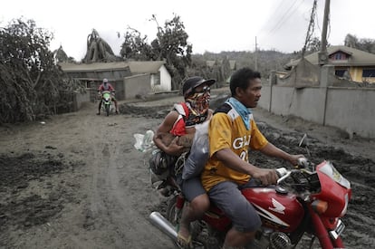 La erupción del volcán Taal en Filipinas ha forzado la evacuación de más de 30.000 personas en los municipios de los alrededores, mientras que la ceniza alcanza ya Manila, la capital del país, situada a unos 60 kilómetros. En la imagen, varios residentes abandonan su aldea cubierta de ceniza, este martes.