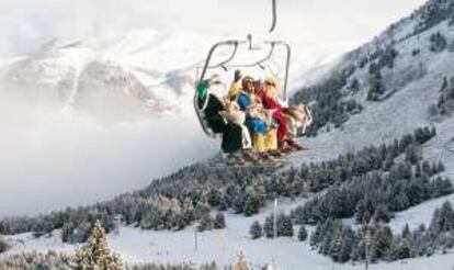Tres esquiadores vestidos de los Reyes Magos en un telesilla de Cerler (Huesca).
