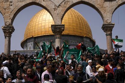 Palestinians hold the Palestinian national flag and the flag of the Hamas militant group during a protest by the Dome of Rock at the Al-Aqsa Mosque.