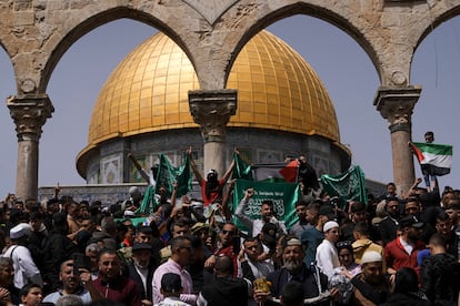 Palestinians hold the Palestinian national flag and the flag of the Hamas militant group during a protest by the Dome of Rock at the Al-Aqsa Mosque.