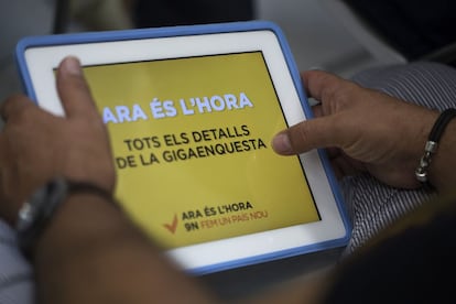 Una persona mira en una tableta el lema de la ANC "Ara és l'hora", en una imagen de archivo.