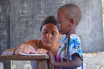 Una voluntaria da clases a un niño en sus vacaciones.