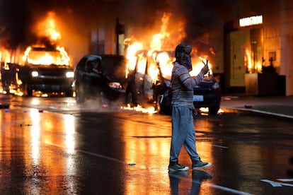 Los Ángeles es la ciudad a la que mira todo el país cuando hay una protesta racial por haber sido el escenario de los peores disturbios del siglo pasado. En la imagen, un joven graba con el móvil mientras varios vehículos arden tras la manifestación en Seattle.