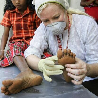 Una niña de 13 años recibe en un hospital de campaña en Sri Lanka los cuidados de una moja de Nueva York.