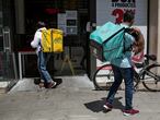 18/05/20 Repartidores de comida para llevar a domicilio, en la imagen, una rider de Glovo y otro de Deliverro recogen sus pedidos en un establecimiento de comida rapida en la carretera de Sants.
Estado de alarma, fase 0. Novena semana de confinamiento generalizado para evitar los contagios por la crisis sanitaria del coronavirus. Barcelona, 18 de mayo de 2020 [ALBERT GARCIA] 
