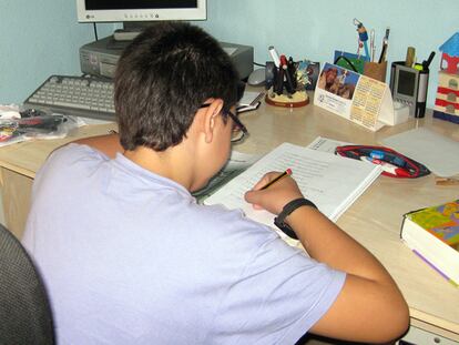 Alex hace los deberes en su escritorio, en su casa, ayer por la tarde.