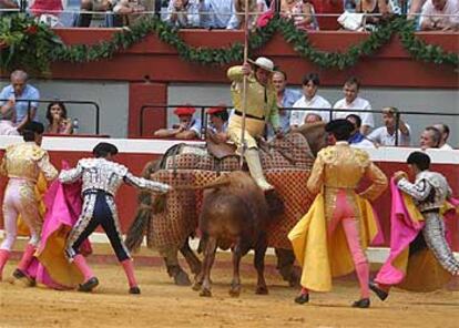 Matías Tejela, a la derecha, observa el intento de separar del caballo a su segundo toro de la tarde.