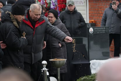 El padre de Navalni, Anatoly Navalni, deposita un puñado de tierra sobre el féretro de su hijo en el cementerio de Borísov.