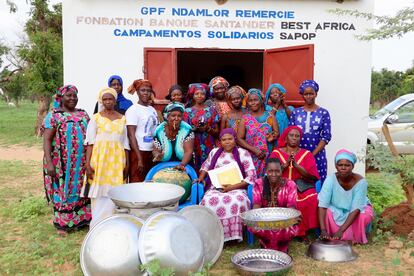 Un grupo mujeres de la asociación Ndamior posa delante del almacén de la cooperativa donde guardan los utensilios que utilizan para las celebraciones. 
