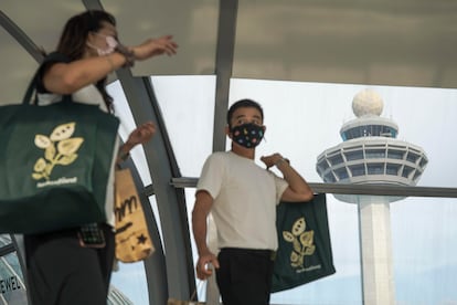 Personas con bolsas de compras en el aeropuerto Changi de Singapur el 10 de mayo.