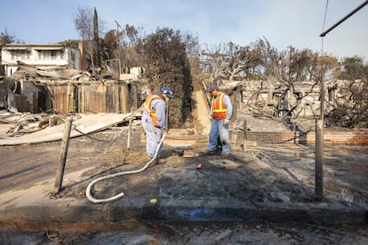 Workers from the gas utility shutting off valves in homes in the burnt area of Sunset Boulevard.
