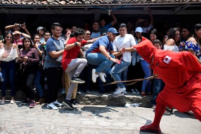 Una persona vestida como un "talciguin" -personaje del folklore local- participa en la celebración de una antigua tradición que marca el inicio de la Semana Santa, en Texistepeque, a unos 80 km al oeste de San Salvador, el 15 de abril de 2019. Los talciguines son demonios que "azotan" a los fieles católicos para limpiar sus pecados. 