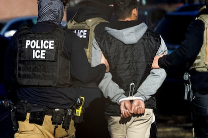 Immigration and Customs Enforcement agents detain a man after conducting a raid at the Cedar Run apartment complex in Denver, Colorado