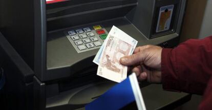 Un hombre retira dinero de un cajero automático.