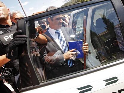 El nuevo alcalde, el popular Martín Urgal, sale del pleno con el bastón de mando y entra, escoltado, en un furgón de la Guardia Civil.