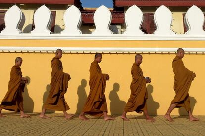 Monjes budistas caminan frente al Palacio Real de Phnom Penh (Camboya).