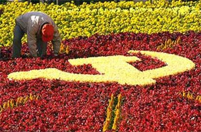 Un jardinero arregla la alfombra de flores en la que se dibuja la hoz y el martillo en vísperas del Congreso del PCCh.