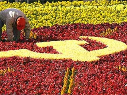 Un jardinero arregla la alfombra de flores en la que se dibuja la hoz y el martillo en vísperas del Congreso del PCCh.