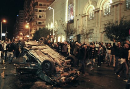 Fieles cristianos protestan junto a uno de los coches destrozados en el atentado frente a una iglesia de Alejandría.