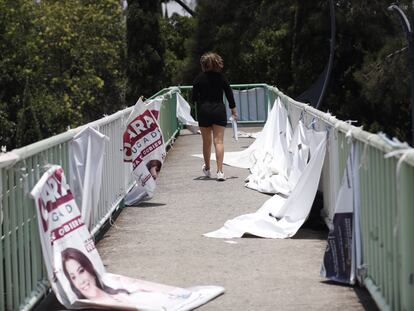 Una mujer camina entre carteles de propaganda electoral, el 24 de mayo en Ciudad de México.