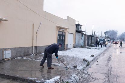 Un hombre barre la nieve de la puerta de su casa en la Cañada Real.